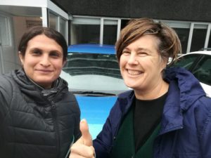 Maya and her volunteer Cathie with her thumb up in front of the dual control car.